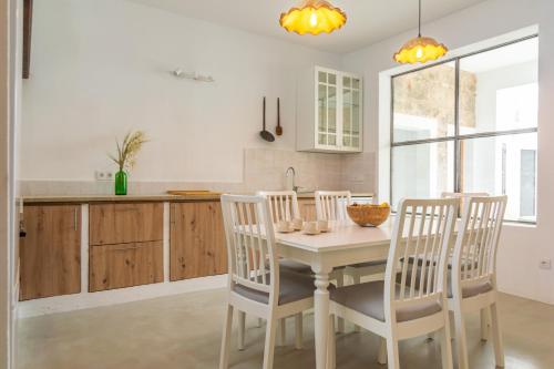 a kitchen with a table and chairs and a sink at Can Serral in Algaida