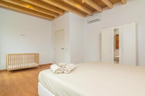 阿爾蓋達的住宿－Can Serral，白色卧室,配有带毛巾的床