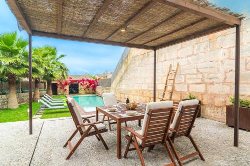 a patio with a table and chairs and a pool at Can Serral in Algaida