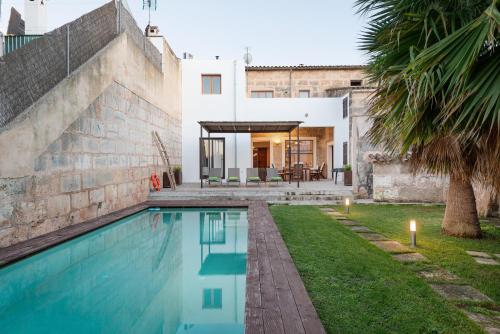 a house with a swimming pool next to a building at Can Serral in Algaida