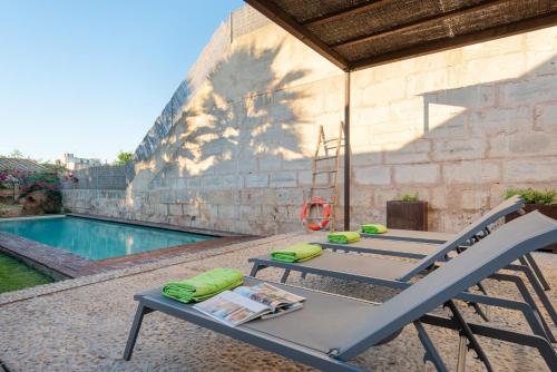 a table and chairs next to a swimming pool at Can Serral in Algaida