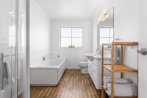La salle de bains blanche est pourvue d'un lavabo et de toilettes. dans l'établissement It's Easy! Space and comfort, à Wanaka
