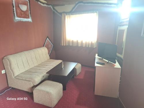 a living room with a couch and a table at Victori SPA in Dobrinishte