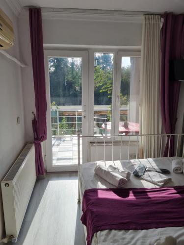 ein Schlafzimmer mit einem Bett und einem großen Fenster in der Unterkunft agva temmuz otel in Sile
