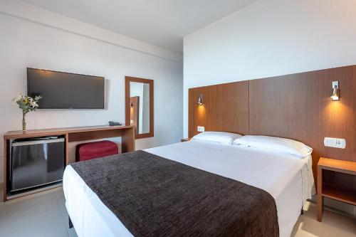 a hotel room with a bed and a flat screen tv at Hotel Playas de Torrevieja in Torrevieja
