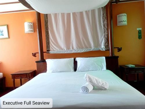 Una cama con dos rollos de papel higiénico. en Alpine LXPD Full Seaview Water Chalet, en Port Dickson