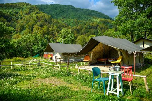 - un groupe de chaises devant une tente dans l'établissement Monkey Mud House and Camps, Bir, à Bir