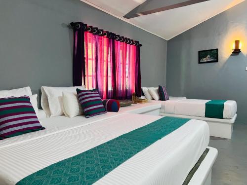 een slaapkamer met 2 bedden en een raam bij Kingfisher Beach Resort -Yala in Kirinda