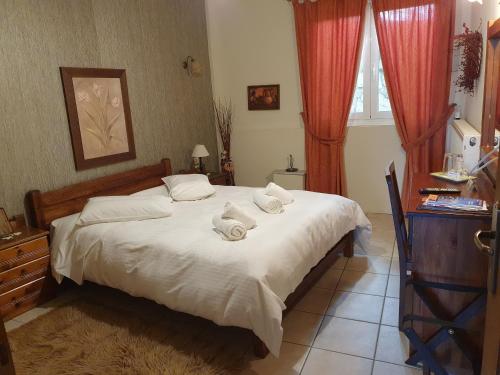a bedroom with a bed with towels on it at Semeli Guesthouse in Karpenision