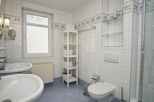 ein weißes Badezimmer mit Toilette und Waschbecken in der Unterkunft mit Meerblick und Balkon, gratis Nutzung vom AHOI Erlebnisbad und Sauna in Sellin - Meeresblick FeWo 38 in Göhren