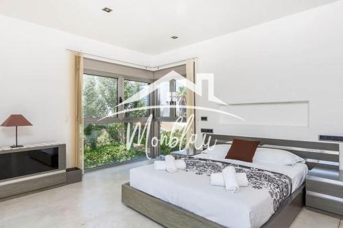 a bedroom with a bed and a large window at Villa Colom in Son Carrio