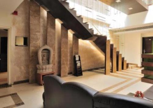 a lobby with a staircase and a couch in a building at Hotel Landmark in Chandīgarh