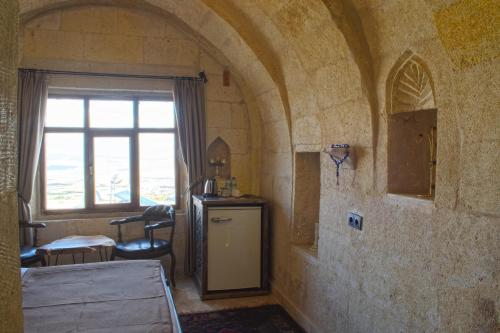 um quarto com uma janela e um quarto com uma mesa em Ages in Cappadocia em Üçhisar