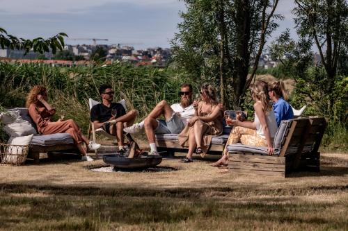 a group of people sitting around a fire pit at Les Jardins de Jeanne in Middelkerke