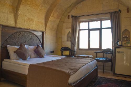 a bedroom with a large bed and a window at Ages in Cappadocia in Uchisar