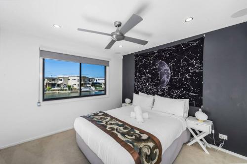a bedroom with a large bed and a window at Luxury Modern Waterfront House in Gold Coast
