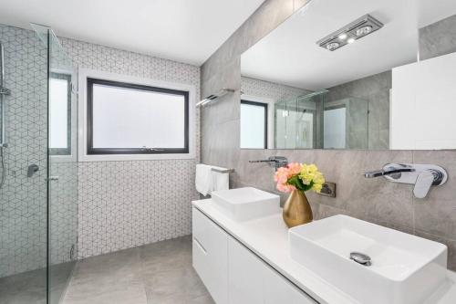 a bathroom with two sinks and a shower at Luxury Modern Waterfront House in Gold Coast