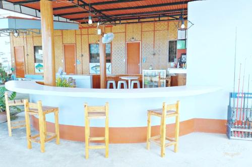 a restaurant with two stools and a counter at Angler's Hub & Resort in Oslob