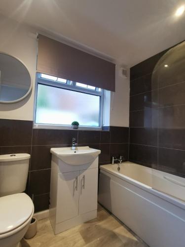 a bathroom with a toilet and a sink and a bath tub at Contractors Home Free Parking 5 MINS To City Centre in Hull