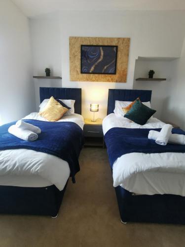 1 dormitorio con 2 camas con sábanas azules y blancas en Contractors Home Free Parking 5 MINS To City Centre, en Hull
