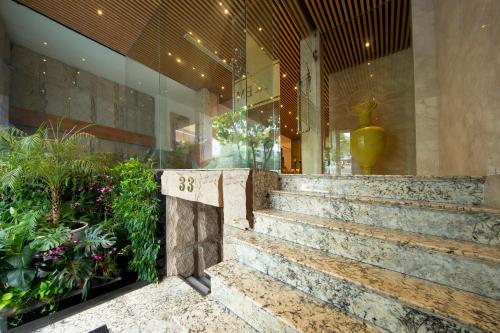 a lobby of a building with stairs and plants at A&EM Art Hotel in Ho Chi Minh City