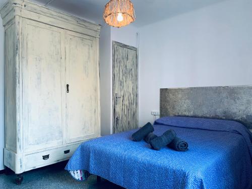 um quarto com uma cama azul e um armário grande em Hauzify I Apartament Monlema em Sant Feliu de Guíxols