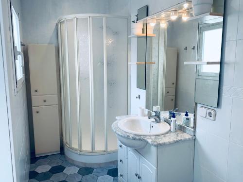 a white bathroom with a sink and a shower at Hauzify I Apartament Monlema in Sant Feliu de Guíxols