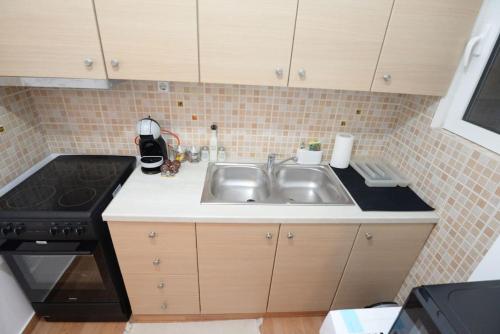 eine Küche mit einer Spüle und einem Herd in der Unterkunft Minimal apartment in koukaki in Athen
