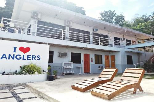 two lounge chairs in front of a building at Angler's Hub & Resort Oslob in Oslob