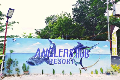 a sign for an americers hub resort on the beach at Angler's Hub & Resort Oslob in Oslob