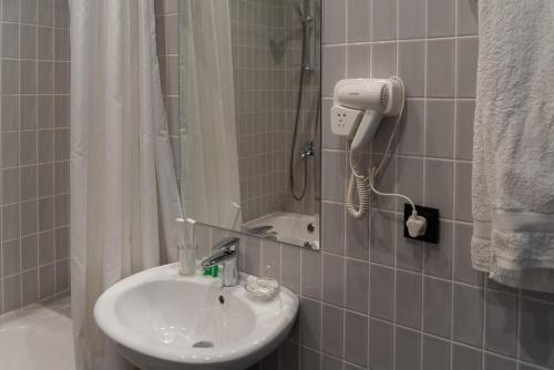 a bathroom with a sink and a shower at Hotel Jipek Joli in Nukus