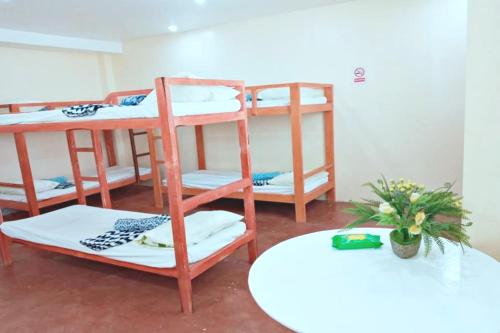 a room with three bunk beds and a table at Angler's Hub & Resort Oslob in Oslob