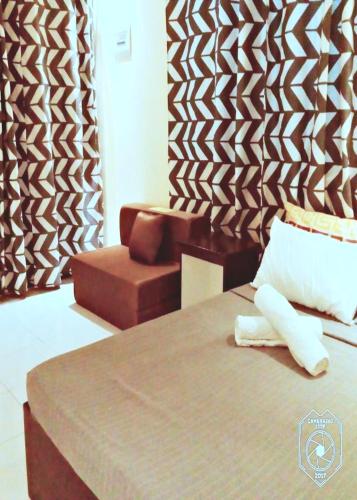 a hotel room with a bed and a chair at Angler's Hub & Resort Oslob in Oslob