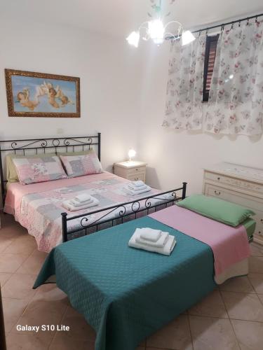 1 dormitorio con 2 camas y toallas. en Agriturismo La Verde Rosa, en Pescia Romana