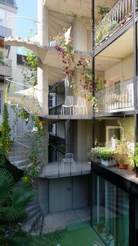 a building with a balcony with chairs and plants at HÜBSCHES APARTMENT im Herzen von Linz in Linz