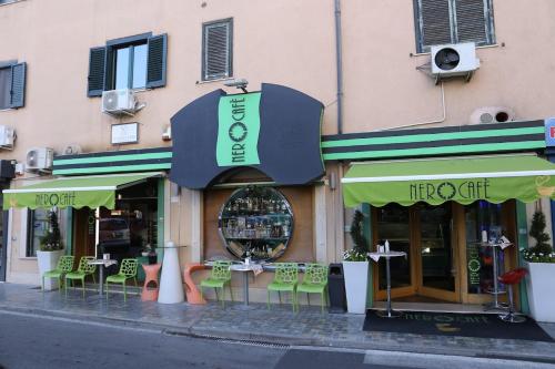 ein Laden mit grünen Sonnenschirmen, Tischen und Stühlen in der Unterkunft Casa Vacanze Rachele in Agropoli