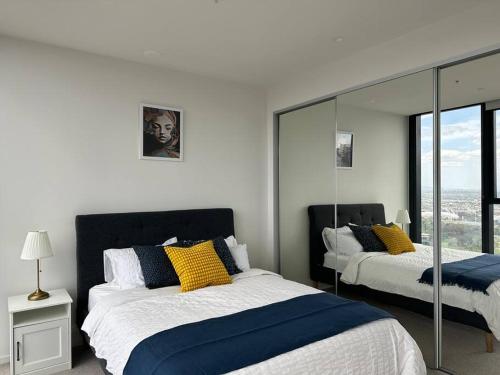 a bedroom with two beds with yellow and blue pillows at Skyline Serenity Retreat in Melbourne