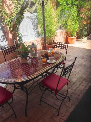 - une table et des chaises sur une terrasse avec des fruits dans l'établissement Chambres d'hôtes Les Noisetiers, à Digne-Les-Bains
