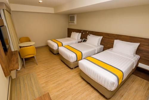 a hotel room with two beds and a chair at SureStay Plus by Best Western Cebu City in Cebu City
