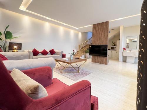 a living room with a red couch and a tv at Abant Chalets in Riyadh