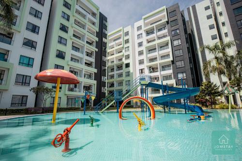 a swimming pool with a playground in a city at Jomstay Manhattan Suites Ipoh Water Park Homestay in Ipoh
