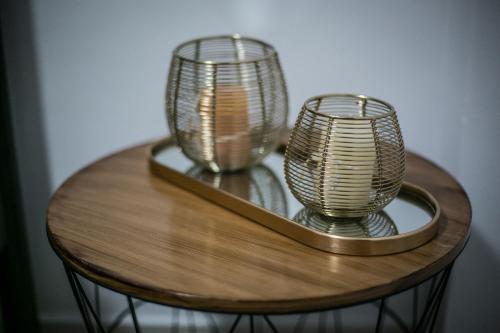 a wooden table with two glass vases on it at Central apartment's in Trikala in Tríkala
