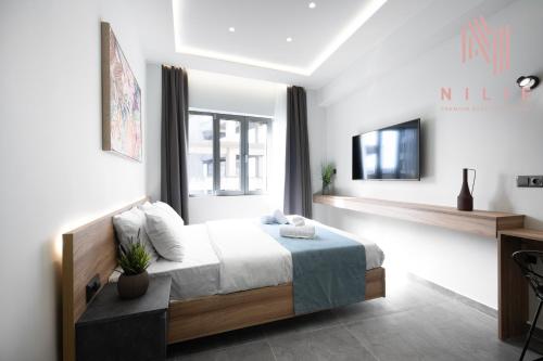 a bedroom with a bed and a tv on a wall at Pantheon, Nilie Hospitality MGMT in Thessaloniki