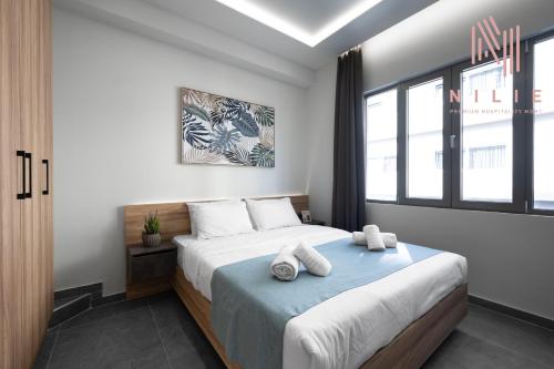 a bedroom with a bed with two towels on it at Pantheon, Nilie Hospitality MGMT in Thessaloniki