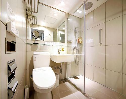 a bathroom with a toilet and a sink and a shower at Travelodge Sapporo Susukino in Sapporo