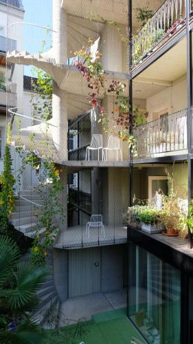 a building with a balcony with chairs and plants at CHARMANTES APARTMENT im Herzen von Linz in Linz