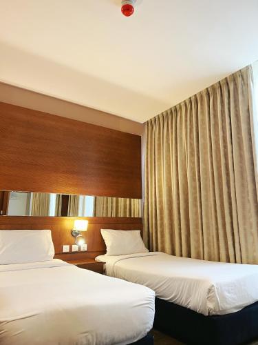 a hotel room with two beds and curtains at The Seventh Star Hotel Suites in Amman