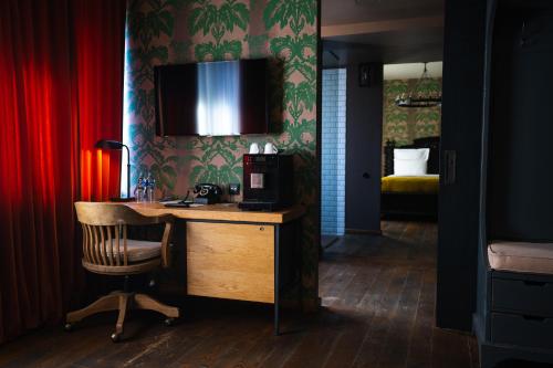 a room with a desk and a television on a wall at Rooms Hotel Tbilisi in Tbilisi City