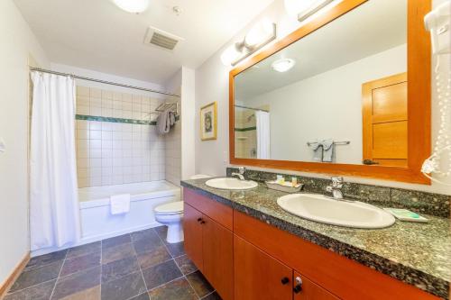 a bathroom with two sinks and a toilet and a mirror at #550 Village, Walk to Gondola 3BD, 3BATH with Spa in Mammoth Lakes