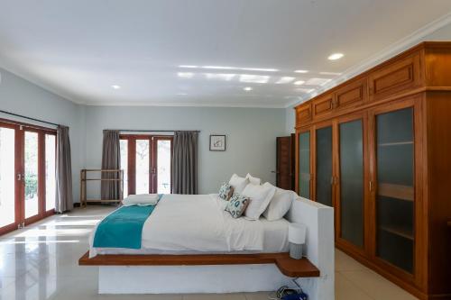 a bedroom with a large bed with wooden cabinets at 3 Bedroom Private House in Gili Trawangan